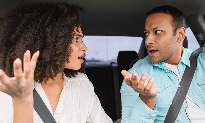 A man and woman in a car having a heated argument, reflecting tension between boyfriend and female bestie. A man and woman in a car having a heated argument, reflecting tension between boyfriend and female bestie.