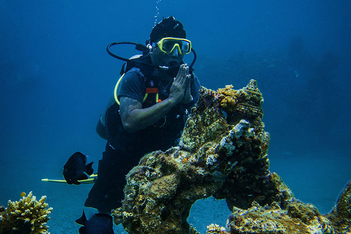 Scuba diver underwater near coral reef, illustrating one of the most dangerous things people willingly or unwillingly did.
