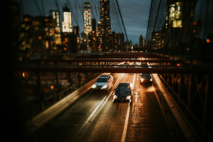 Nighttime view of cars speeding on a busy urban bridge, illustrating one of the most dangerous things people willingly do.