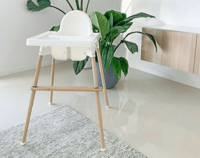 White high chair in a modern room with plants and wooden furniture, illustrating awkward moments in the service industry.