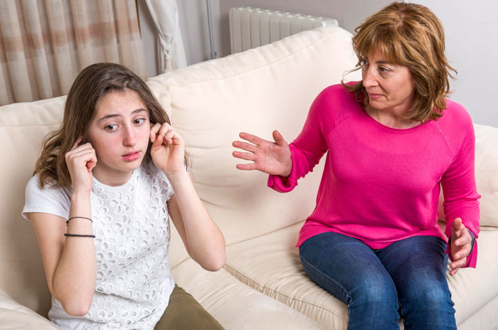 Annoyed mom and 15-year-old daughter arguing on couch as daughter refuses to do chores seen as pick me behavior. Annoyed mom and 15-year-old daughter arguing on couch as daughter refuses to do chores seen as pick me behavior.