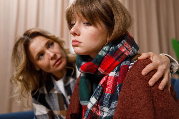 Daughter stepping up to help mom, offering comfort and support during a difficult emotional moment indoors.
