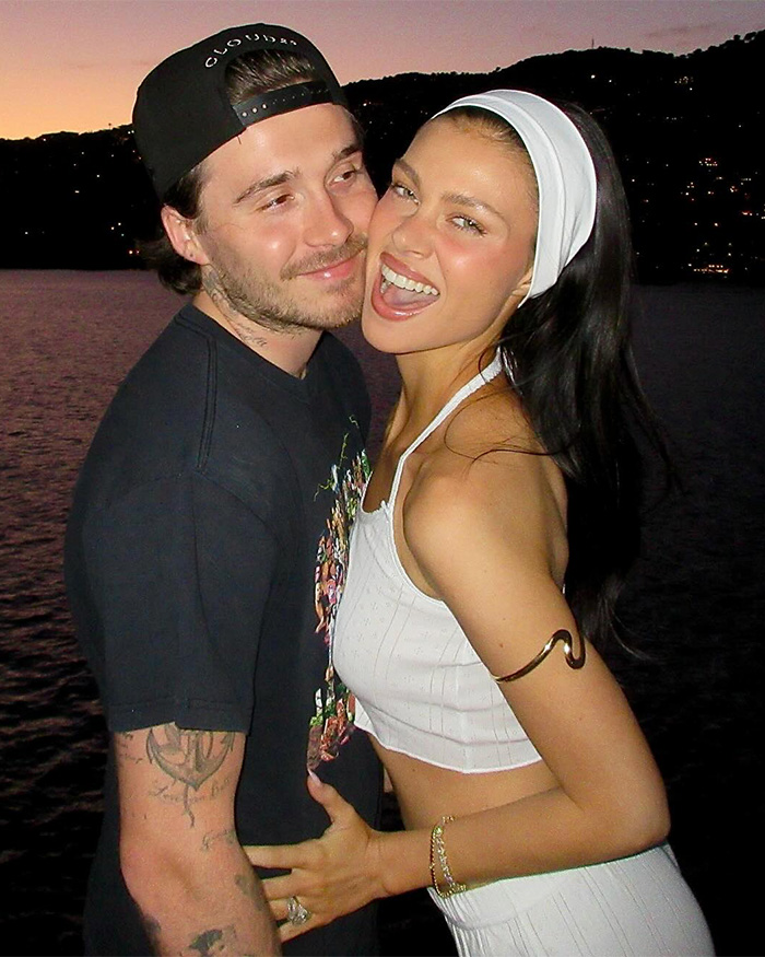 Young couple smiling and hugging at sunset by the water, relating to David Beckham public teasing son family rift crisis. Young couple smiling and hugging at sunset by the water, relating to David Beckham public teasing son family rift crisis.