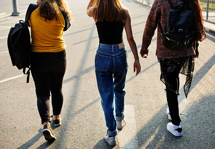 Three women walking together outdoors, one appearing upset about an unplanned walking trip despite her diabetes condition.