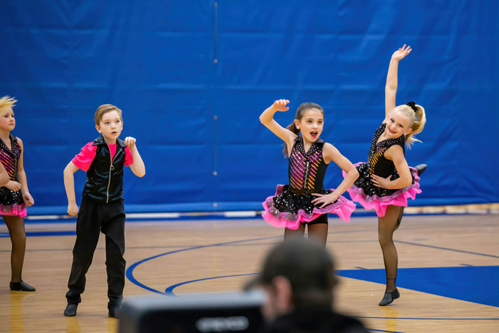 Children performing a dance routine in a gymnasium, illustrating themes of trust and deception like a husband telling wife about camping trip. Children performing a dance routine in a gymnasium, illustrating themes of trust and deception like a husband telling wife about camping trip.
