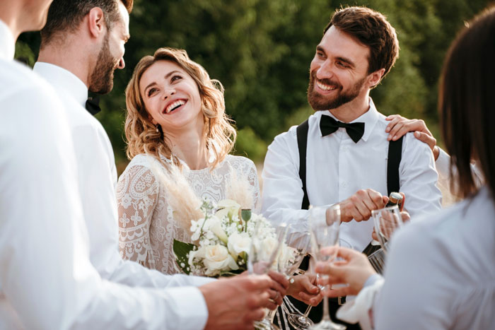 Bride and groom celebrating engagement hold with friends outdoors, smiling and raising glasses in a joyful moment. Bride and groom celebrating engagement hold with friends outdoors, smiling and raising glasses in a joyful moment.