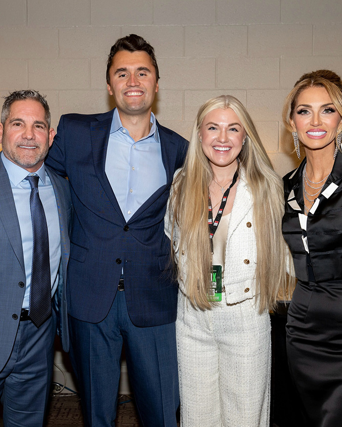 Erika Kirk posing with three people, showing her makeup transformation before Charlie's assassination event. Erika Kirk posing with three people, showing her makeup transformation before Charlie's assassination event.