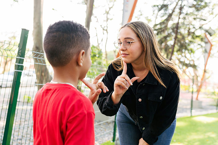 Woman and child outdoors communicating with hand signs, illustrating moments people realized the expert was wrong.
