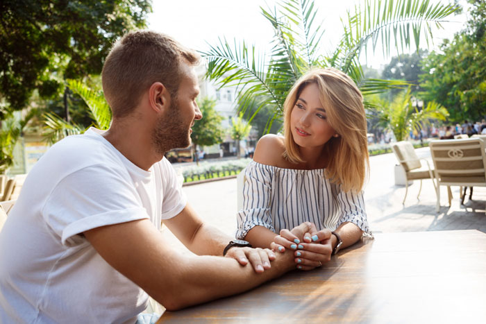 Couple having a tense conversation while holding hands outdoors, highlighting therapy battle and relationship boundaries. Couple having a tense conversation while holding hands outdoors, highlighting therapy battle and relationship boundaries.