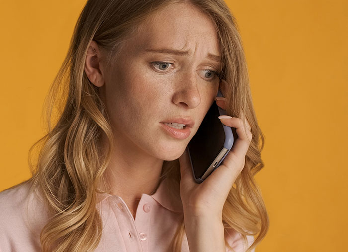 Distressed woman on phone reacting after boyfriend breaks off engagement Distressed woman on phone reacting after boyfriend breaks off engagement