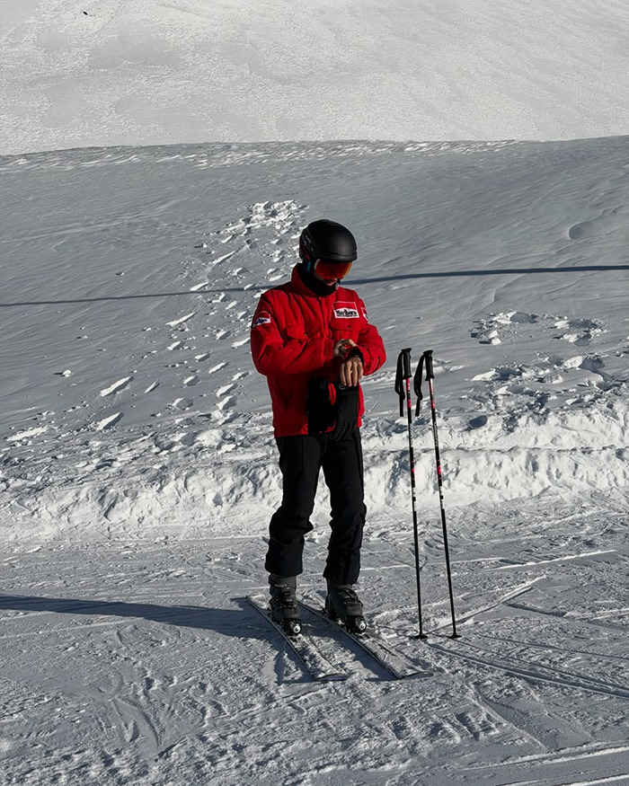 Pierre Gasly skiing on snowy slope in red jacket and black helmet amid Michael Schumacher tribute backlash in F1 context. Pierre Gasly skiing on snowy slope in red jacket and black helmet amid Michael Schumacher tribute backlash in F1 context.