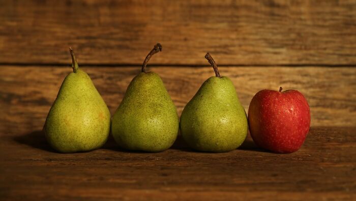 Three green pears and one red apple arranged in a row as an odd-one-out question to trick your mind.