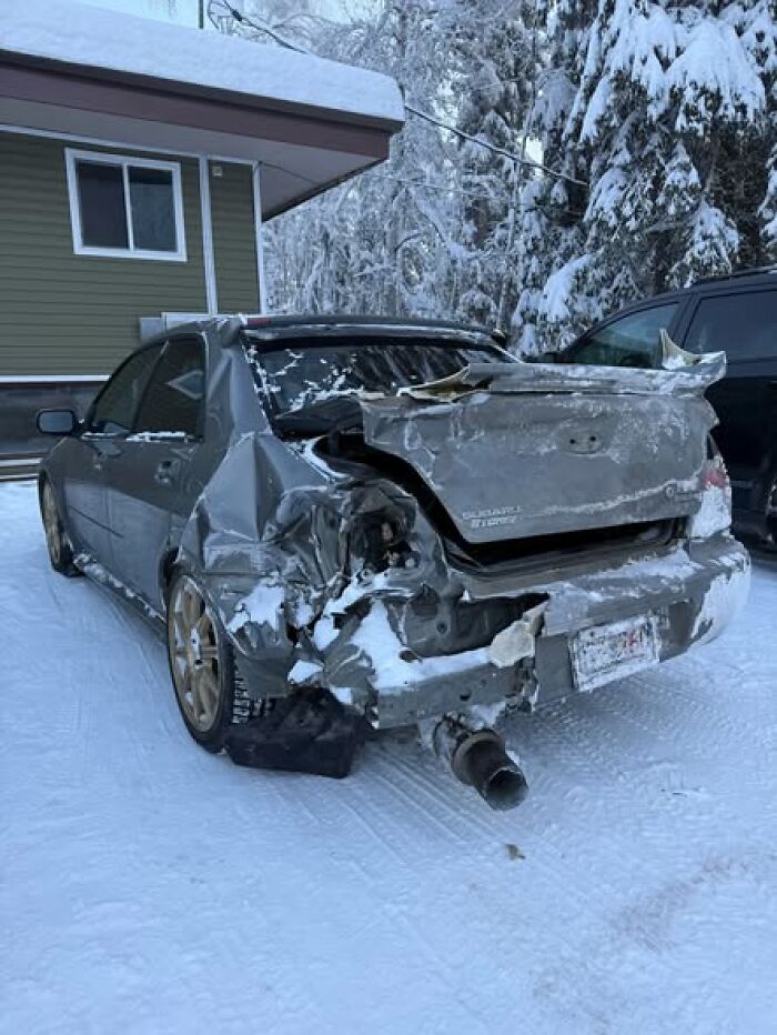 Crushed rear bumper of a car in snow, woke up expecting a normal day