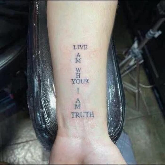 Tattoo on forearm with confusing vertical text causing people to break their brain trying to understand what they read.