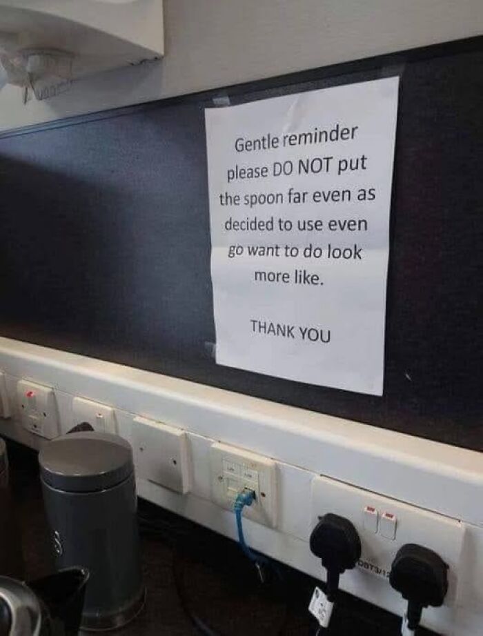 Confusing printed sign on a wall beside electrical outlets, illustrating people breaking their brain trying to understand what they read.