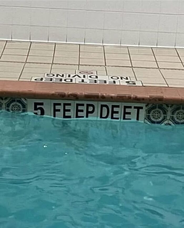 Pool depth sign reading 5 feet misspelled as FE EEP DEET with a no diving sign on the pool deck.