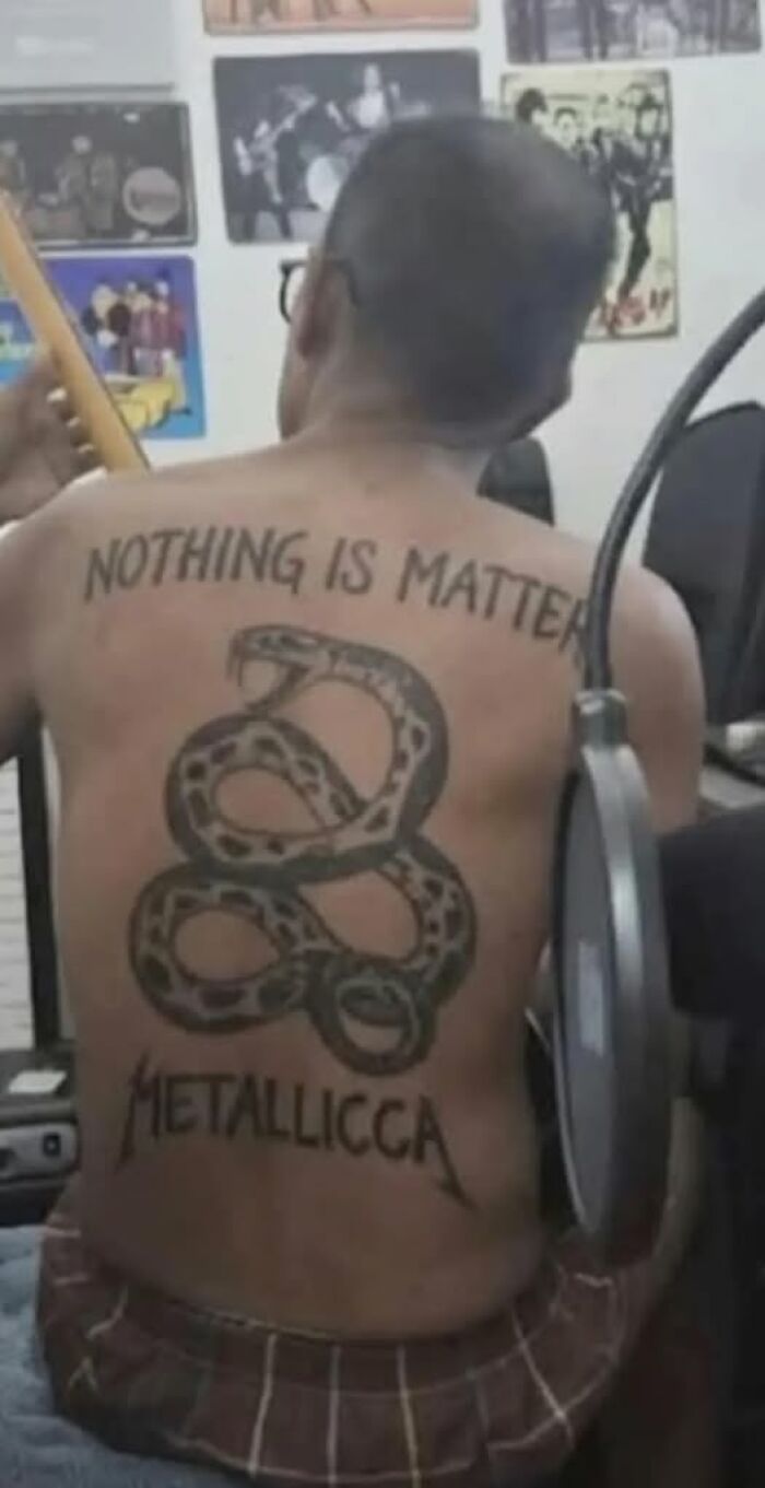 Man with large tattoo saying nothing is matter and metalllicca with a snake, showing a funny broken brain reading misunderstanding.