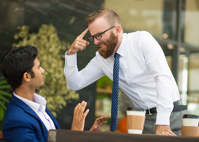 Two men in a heated discussion at a caf&eacute;, illustrating the concept of the male Karen debated by Gen Z.