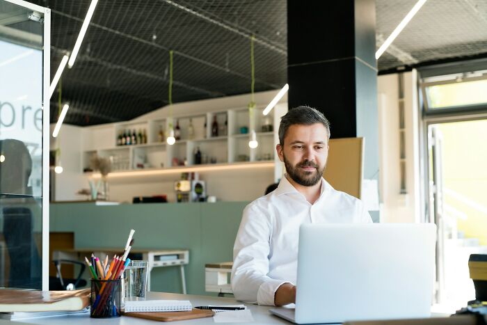 Man working on a laptop in a modern office highlighting daily dangers you might not realize you’re exposing yourself to.