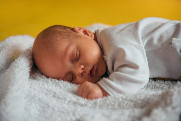 Sleeping infant resting on a soft blanket, illustrating patient vulnerability in examples of a doctor doing something unethical.