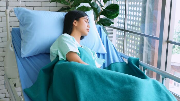 Young woman resting in hospital bed, symbolizing unexplainable medical events with a really bad prognosis.