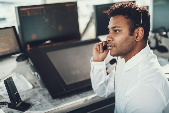 Man wearing headset at control center desk, focused on communication, illustrating weird things people did in public.