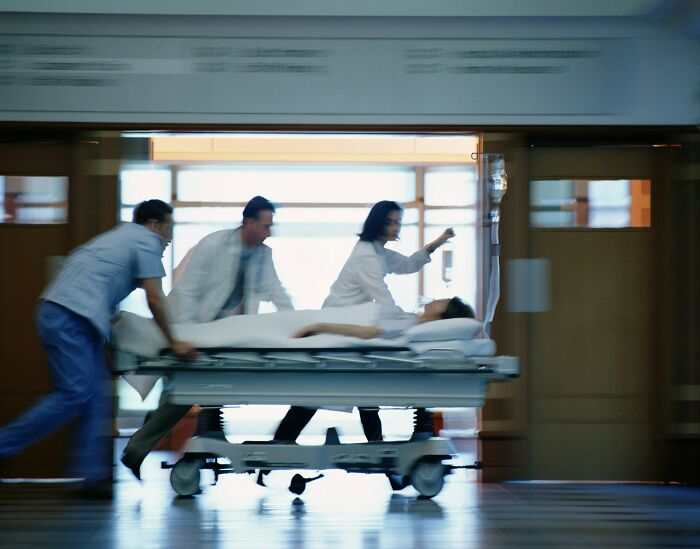 Medical staff rushing a patient on a stretcher in a hospital corridor illustrating unethical doctor behavior with patients.