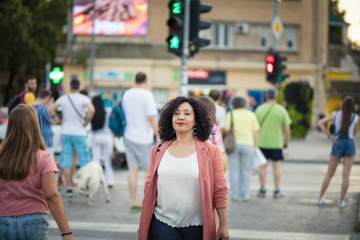 Woman walking confidently in a busy urban area, representing things women do to feel safer while living alone. Woman walking confidently in a busy urban area, representing things women do to feel safer while living alone.
