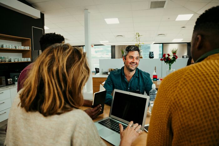 A group of coworkers having a lively discussion in an office, highlighting the worst coworkers ever experiences.