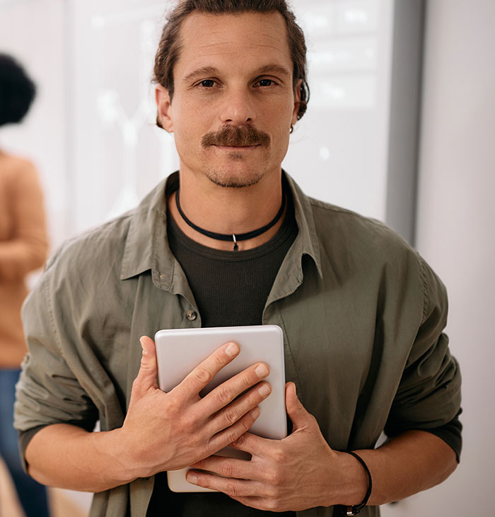Young man holding tablet, representing gifted kids with potential to do great things in a modern setting.