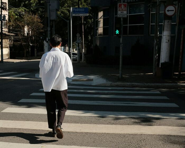 Person walking across a city crosswalk highlighting daily dangers pedestrians might face without realizing it