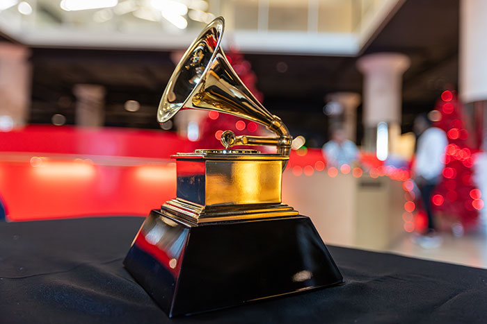 Golden Grammy trophy on a table with blurred background illustrating the impact of Grammy snubs on fans.