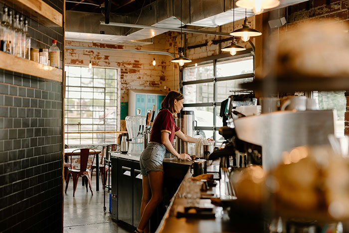 Barista preparing coffee drinks in a rustic cafe where a guy tries to skip coffee line every morning. Barista preparing coffee drinks in a rustic cafe where a guy tries to skip coffee line every morning.