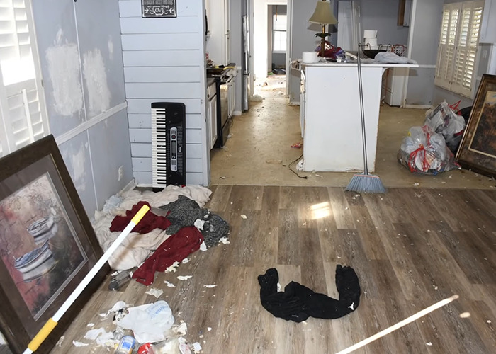 Interior of a cluttered and neglected mobile home showing scattered trash and abandoned belongings reflecting a horrific situation.
