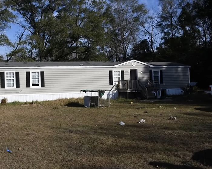 Exterior view of an isolated mobile home with yard litter, linked to a girl abandoned for a year in a devastating situation. Exterior view of an isolated mobile home with yard litter, linked to a girl abandoned for a year in a devastating situation.