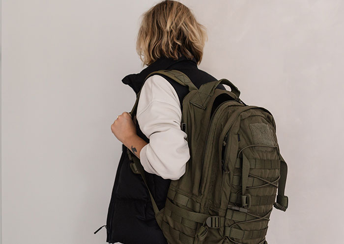 Person with a large backpack facing away, representing challenges faced by homeless people and their horrifying experiences.