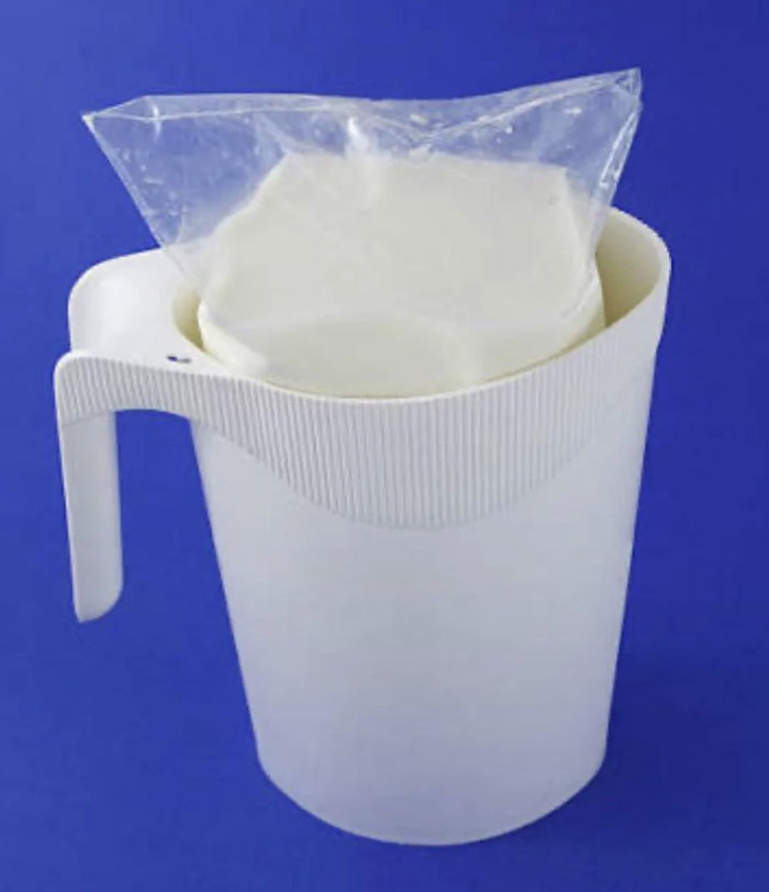 Plastic pitcher holding a sealed plastic bag of milk, a unique household item seen in some countries only.
