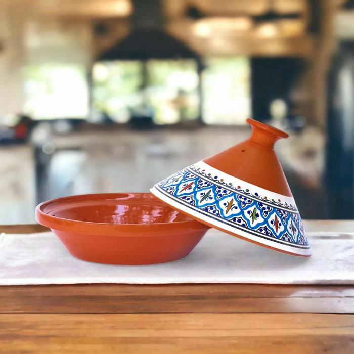 Traditional Moroccan tagine cookware with colorful patterned lid on wooden table, unique household item from a specific country