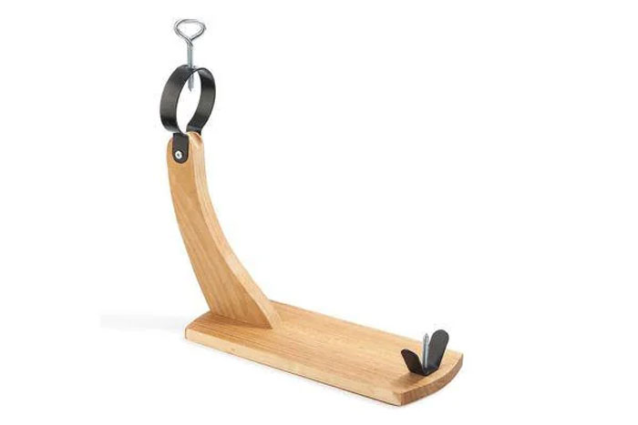 Wooden household item with metal holder used for securing and slicing cured meats, unique to certain countries.