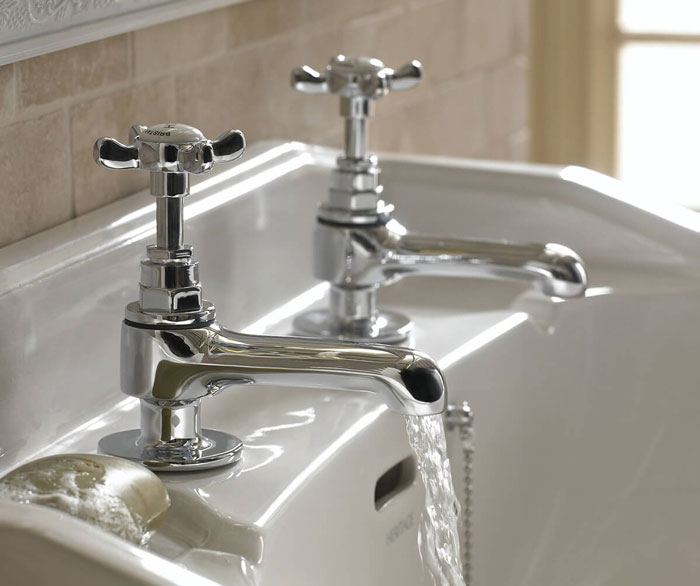 Close-up of unique household items with classic chrome taps in a bathroom sink, showcasing uncommon fixtures from different countries.