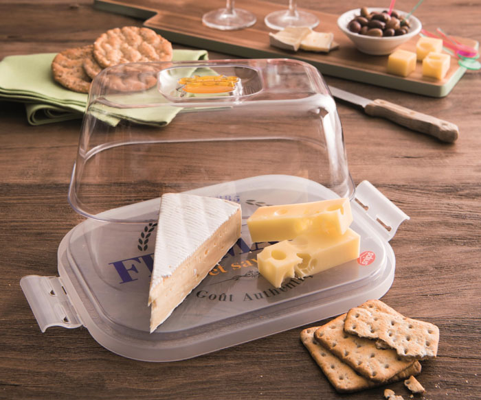 Transparent plastic cheese storage container with assorted cheeses and crackers, showcasing unique household items from different countries.