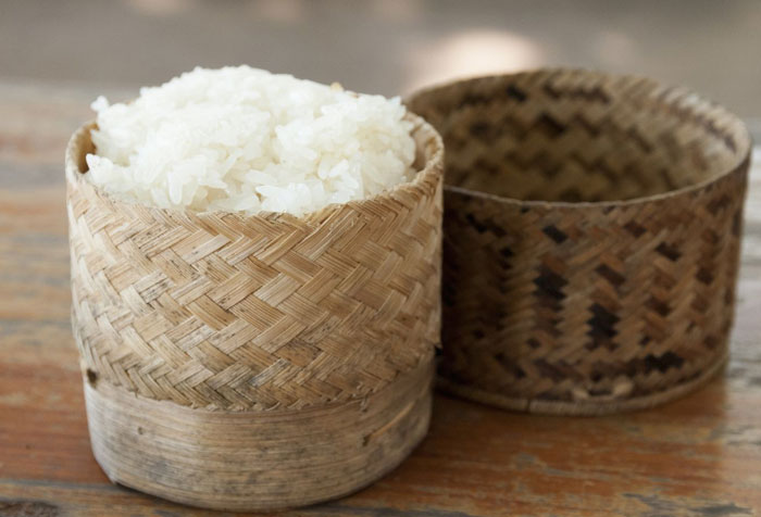 Woven bamboo container filled with white rice, a unique household item shared by 100 people from different countries.