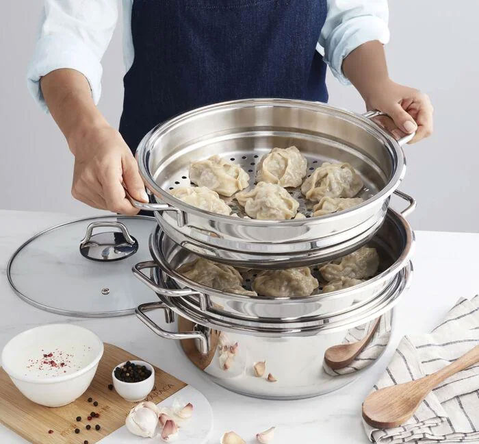 Person using a multi-tiered stainless steel steamer pot, a unique household item shared from various countries.