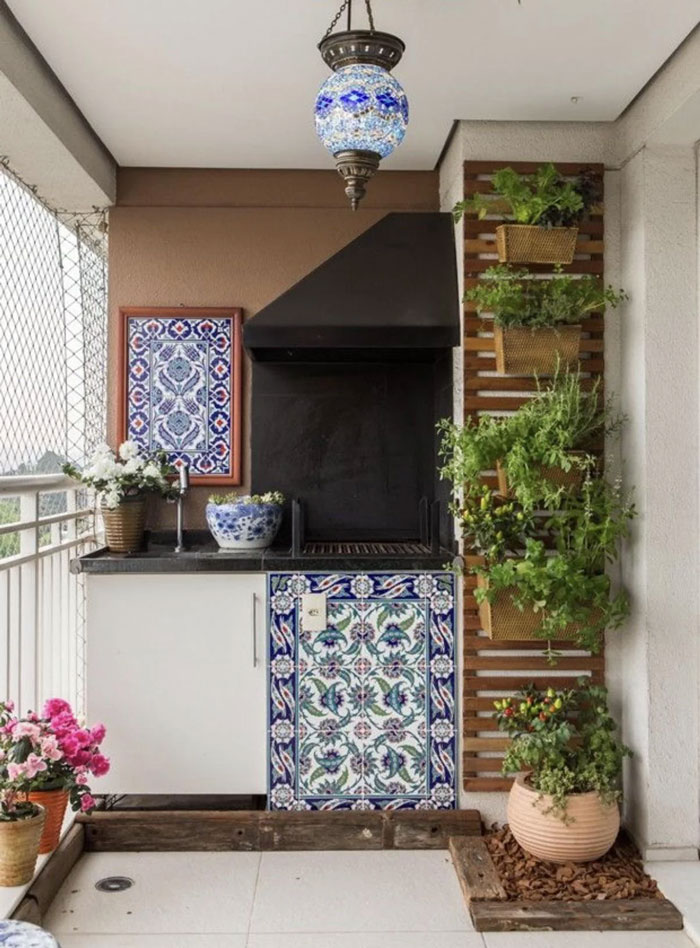 Decorative tiled outdoor barbecue area with hanging plants and mosaic lamp showcasing unique household items.