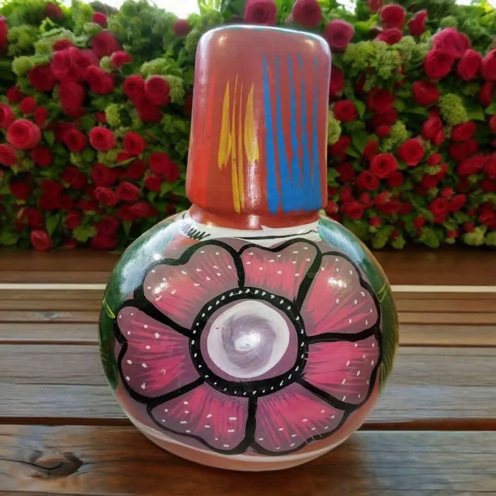 Colorful handmade household item with floral design, unique to certain countries, displayed on a wooden surface with flowers.