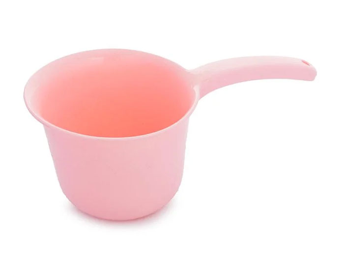 Pink plastic household item with handle, commonly found in certain countries and rare in others, used for scooping liquids.