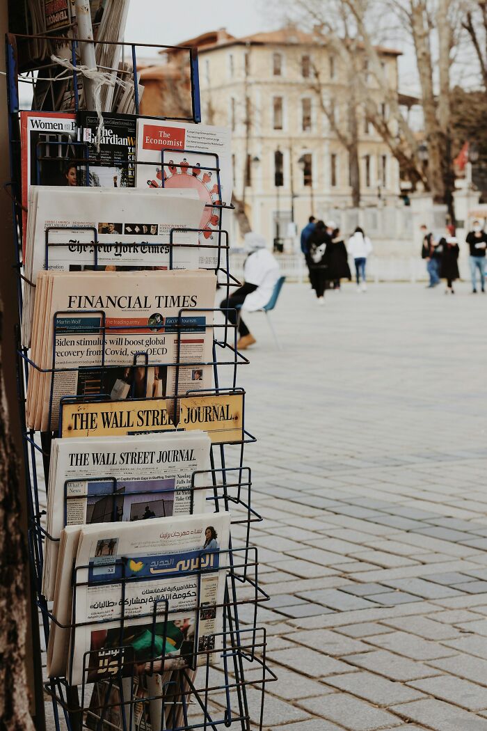Newsstand with various international newspapers in an urban setting, illustrating weird teacher behavior witnessed in class stories.