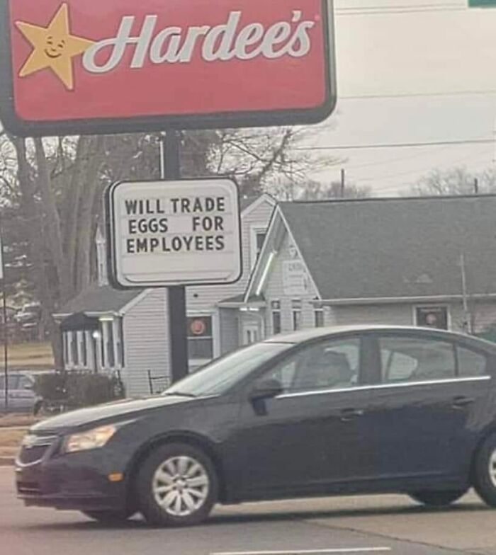 Hardee's sign outside with message offering eggs in exchange for employees, highlighting a dystopia job market reality.