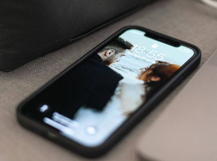 Smartphone screen showing a couple&rsquo;s photo, illustrating a woman&rsquo;s casual boyfriend in a complicated situationship.