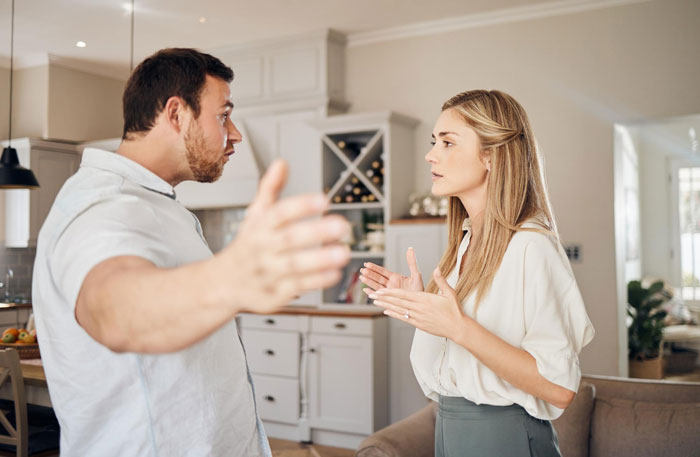 Man expressing frustration while wife asserts her autonomy during a tense conversation in their home.